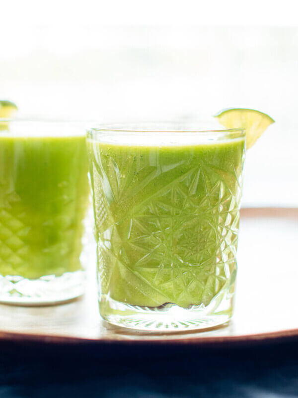 This "mango-rita" green smoothie recipe is made with frozen mango and pineapple, fresh orange, spinach and lime! cookieandkate.com